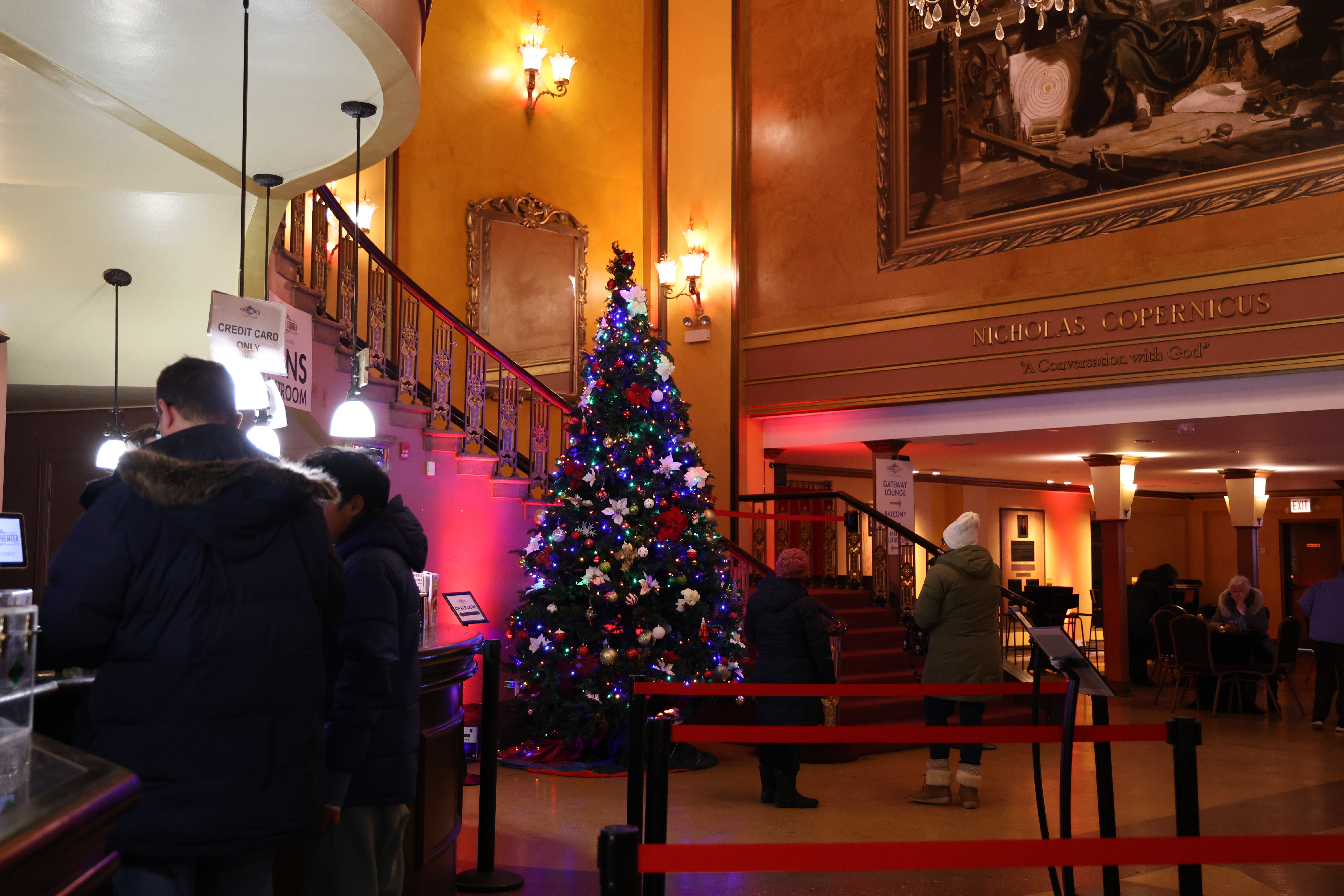 Ornate hall with a large, decorated Christmas tree.